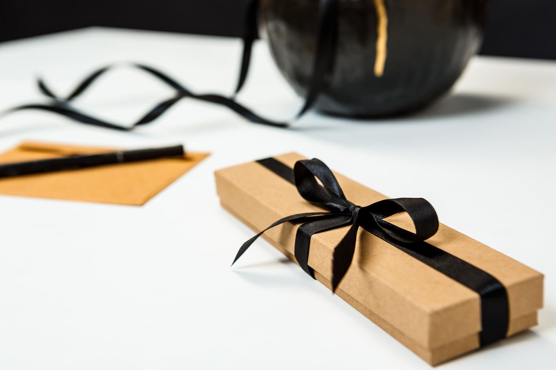 Embalagem elegante com fita preta para presentes especiais.